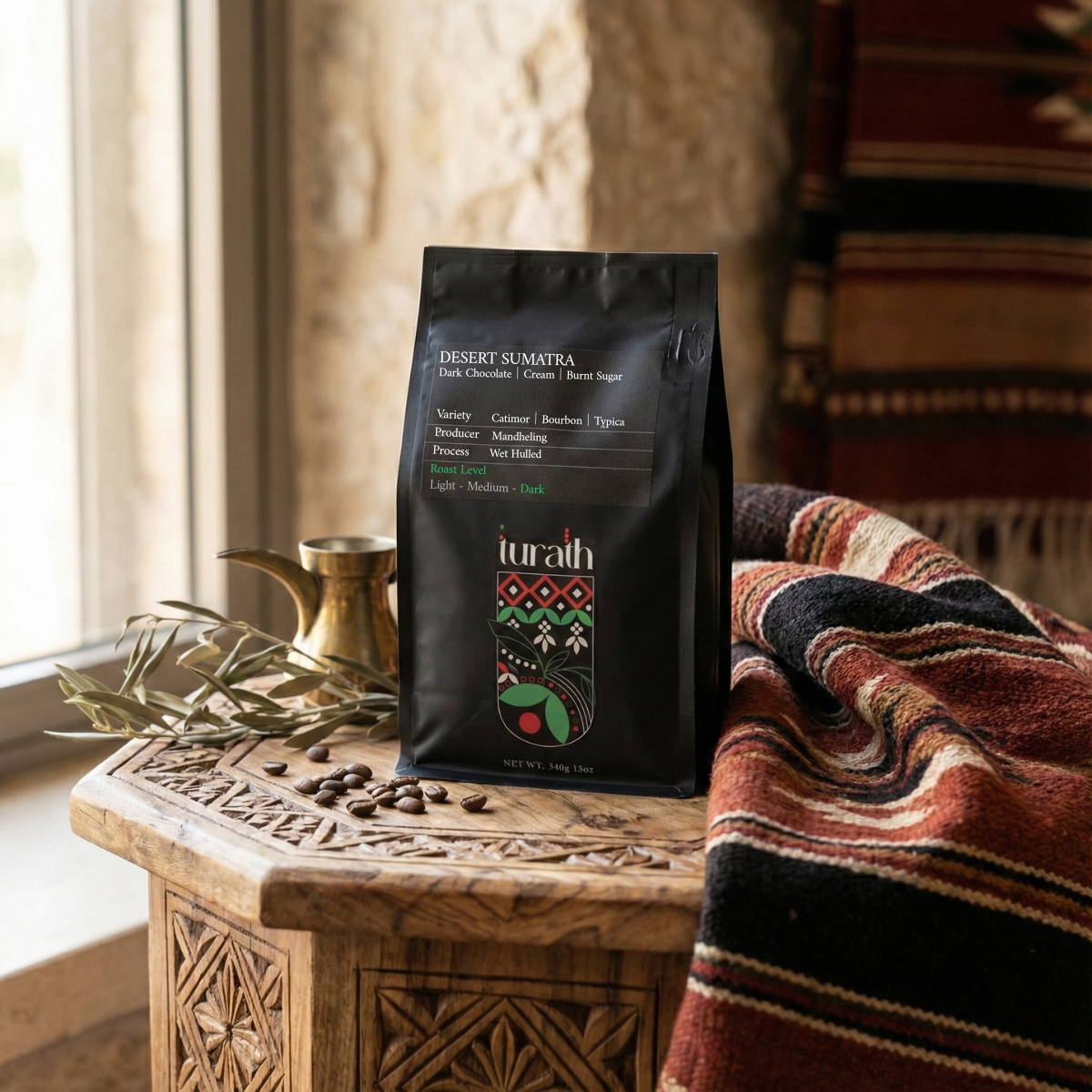 Turath coffee bag on a wooden table with a patterned blanket and window in the background